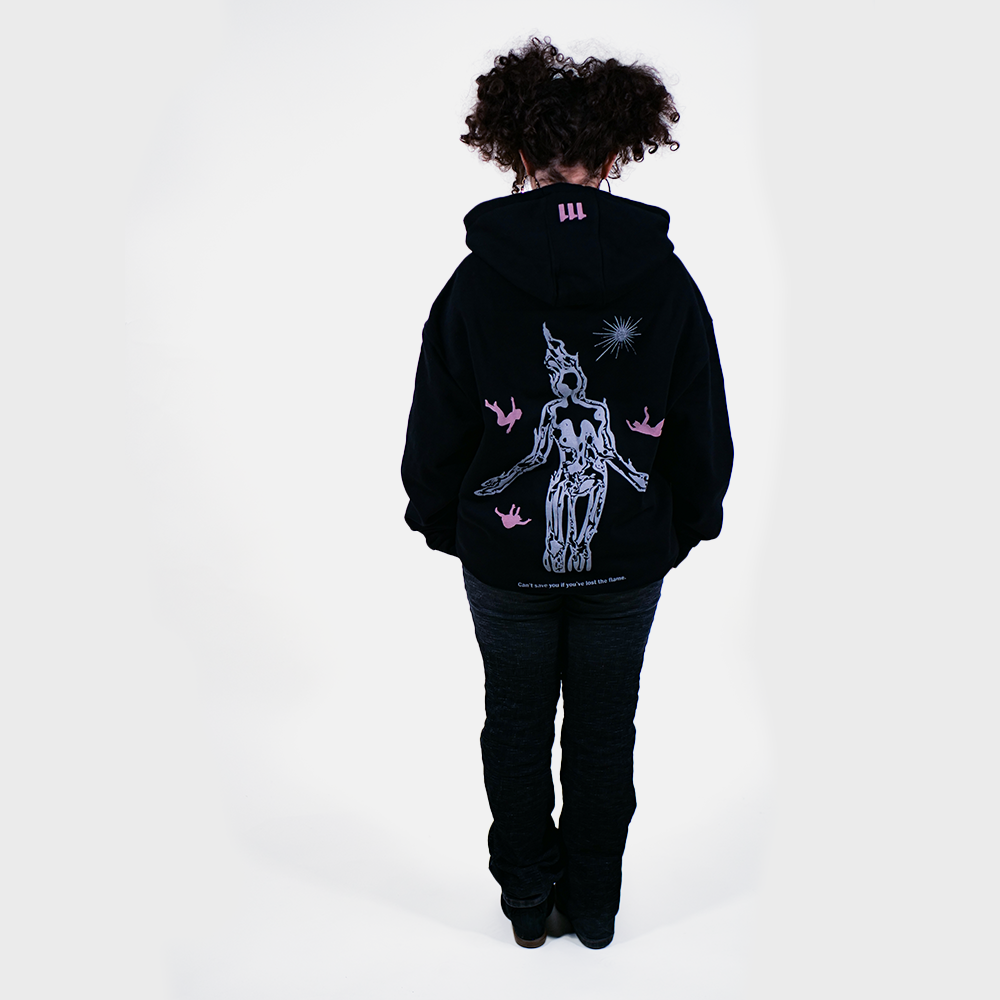Jeune femme portant le sweatshirt Marginal, en portant ce vêtement marginal elle a pour objectif de transmettre un message puissant : brûler de passion.

Le personnage central, touché par la grâce de la passion brule et rayonne tandis que les autres tombent